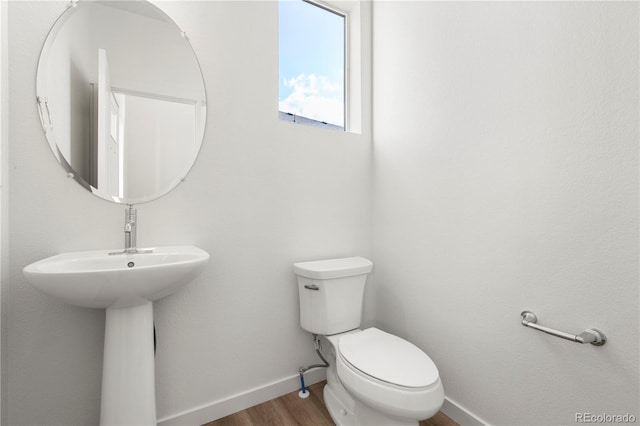 bathroom with toilet and wood-type flooring