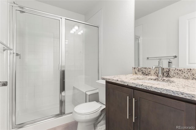 bathroom with vanity, an enclosed shower, and toilet