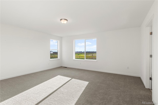 spare room with dark colored carpet