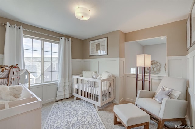 1193 Highview Dr, Erie, CO 80516 - bedroom featuring a decorative wall, wainscoting, light colored carpet, and a nursery area