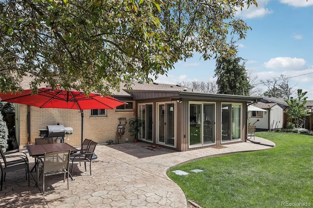 1164 W 101st Pl, Northglenn, CO 80260 - rear view of house featuring a patio, a lawn, brick siding, a storage shed, and outdoor dining area