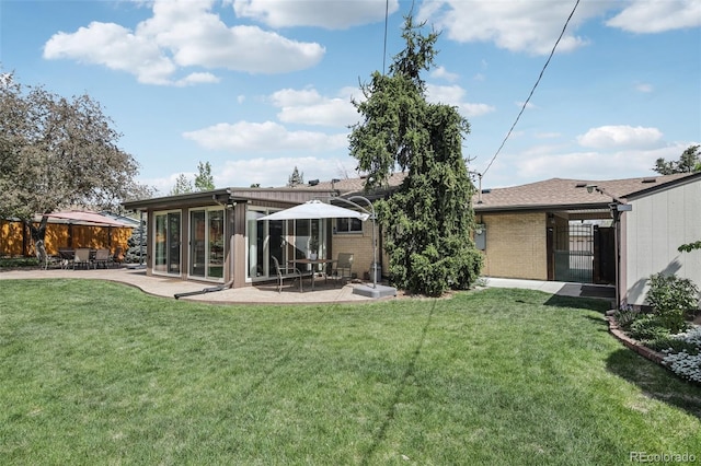 1164 W 101st Pl, Northglenn, CO 80260 - rear view of house with a patio area, brick siding, and a sunroom