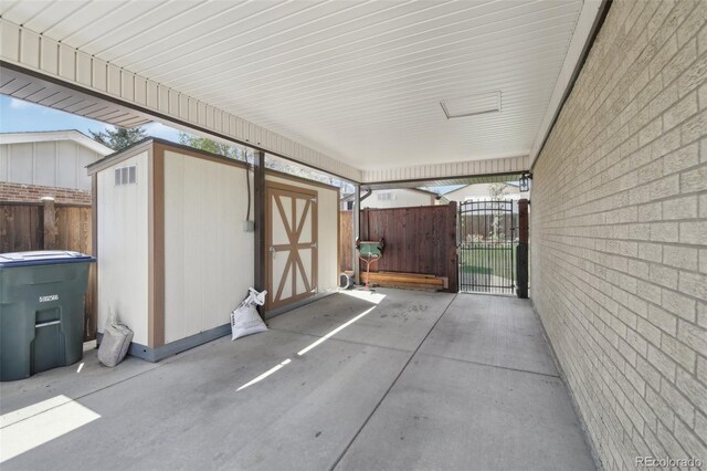 1164 W 101st Pl, Northglenn, CO 80260 - view of patio featuring a storage shed, a gate, an outbuilding, and fence