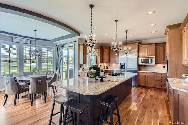 kitchen with built in appliances, a chandelier, light wood-type flooring, and recessed lighting