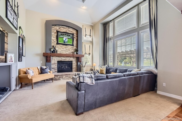 carpeted living area featuring a fireplace and baseboards