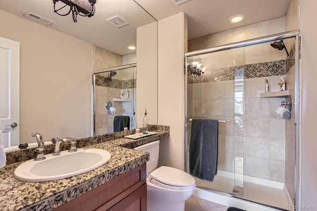 full bathroom featuring a stall shower, vanity, toilet, and tile patterned floors