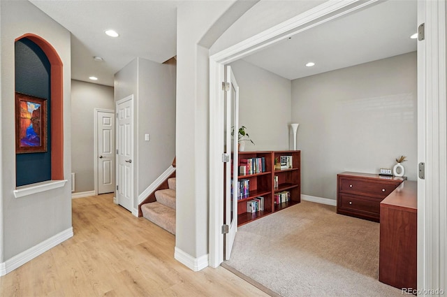 hallway featuring baseboards, recessed lighting, light wood-style floors, and stairway