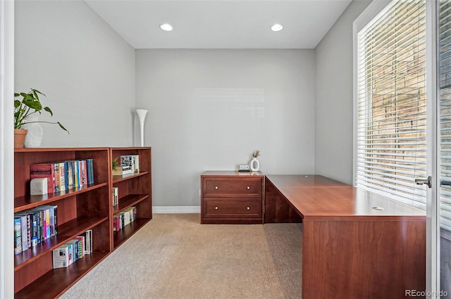 carpeted office space featuring a healthy amount of sunlight and baseboards