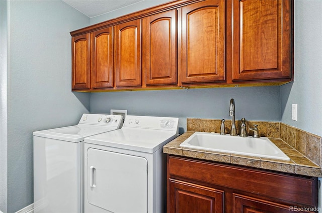 washroom featuring a sink, cabinet space, and washer and dryer