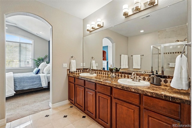 bathroom with a sink, tile patterned floors, a stall shower, and double vanity