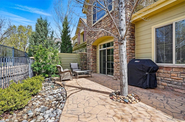 view of patio with fence and a grill