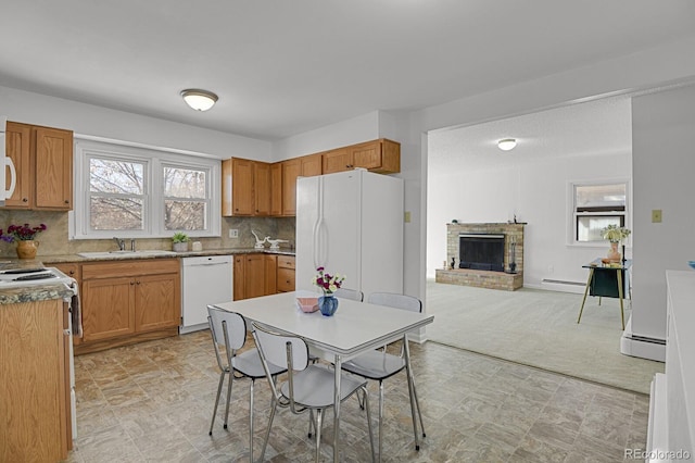 kitchen with a brick fireplace, tasteful backsplash, a baseboard heating unit, light colored carpet, and white appliances