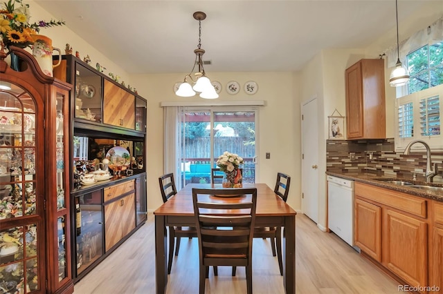 dining room featuring light wood finished floors, healthy amount of natural light, and a chandelier