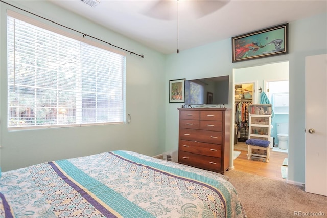 bedroom featuring multiple windows, a walk in closet, carpet floors, and a closet