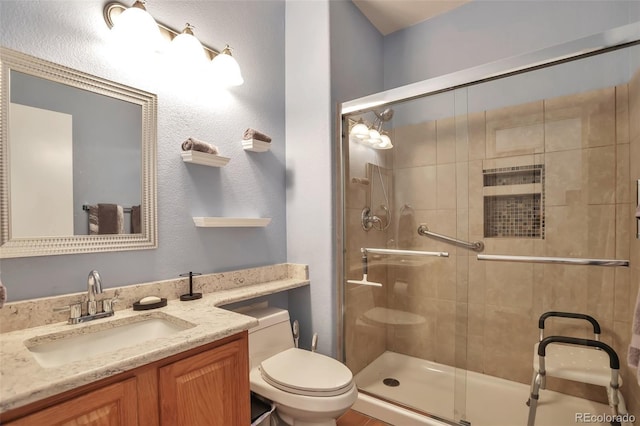 full bath featuring toilet, a stall shower, and vanity