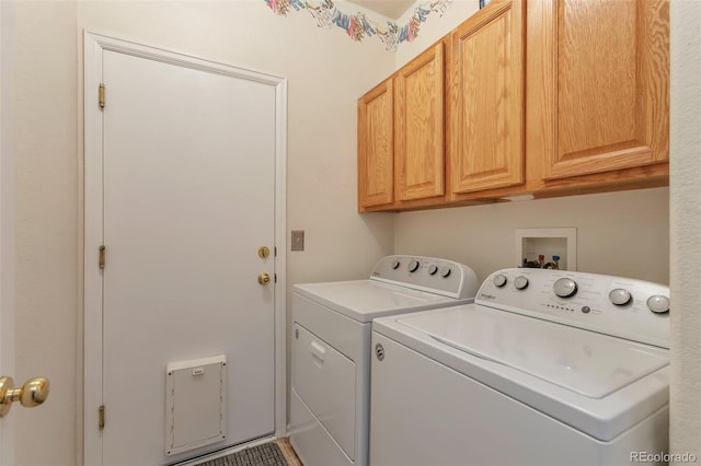 washroom with washing machine and dryer and cabinet space