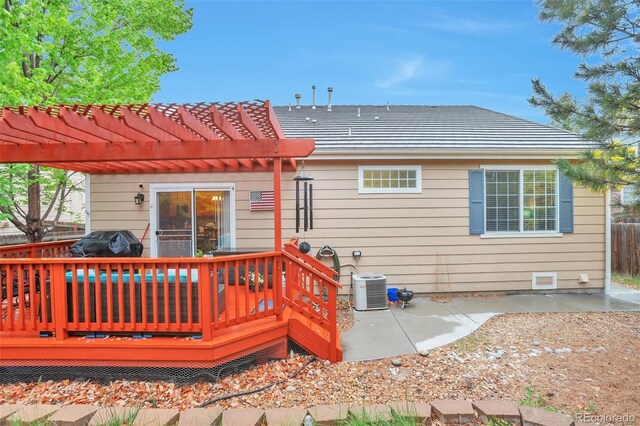 back of property with a pergola, a wooden deck, a patio, central AC unit, and fence