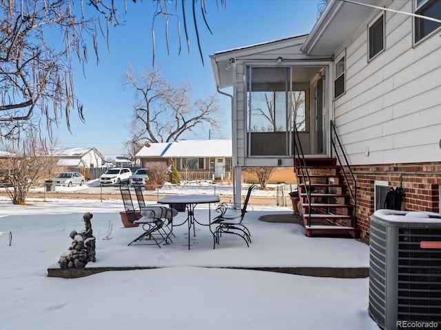 snow covered patio with central AC unit