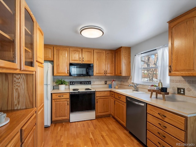 kitchen with sink, light hardwood / wood-style flooring, electric range oven, white refrigerator, and stainless steel dishwasher