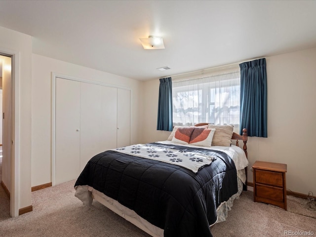 bedroom featuring light colored carpet and a closet