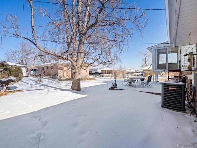 snowy yard featuring central AC unit