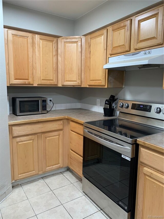 kitchen featuring light tile patterned flooring, light brown cabinets, and stainless steel appliances