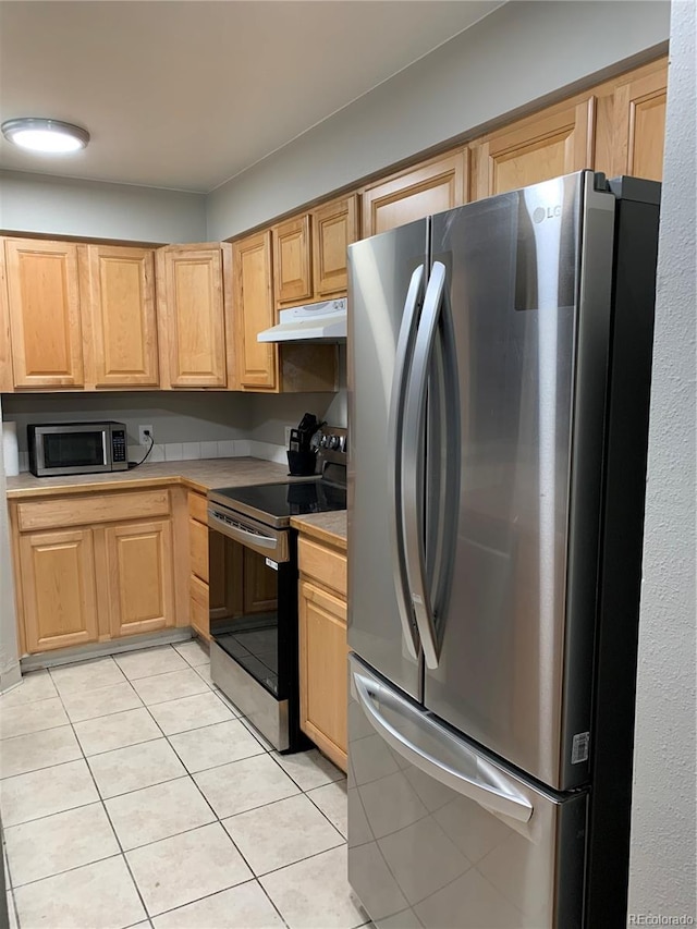 kitchen featuring light tile patterned flooring, light brown cabinets, and stainless steel appliances