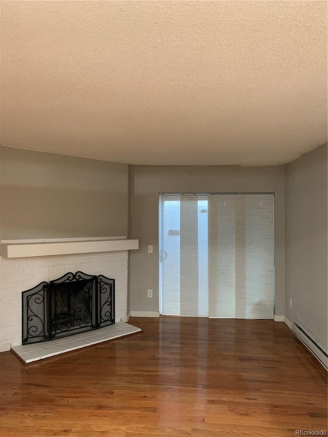 unfurnished living room featuring a textured ceiling, hardwood / wood-style flooring, and a fireplace