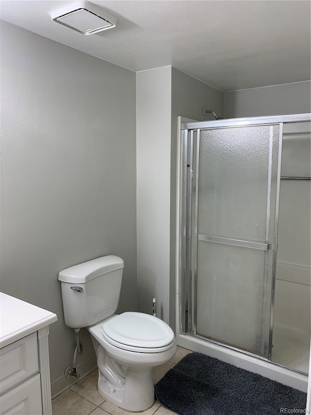 bathroom with tile patterned flooring, vanity, toilet, and a shower with shower door