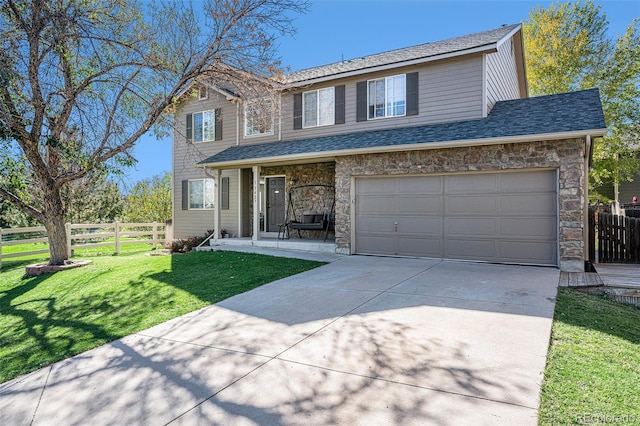 view of property featuring a garage and a front lawn