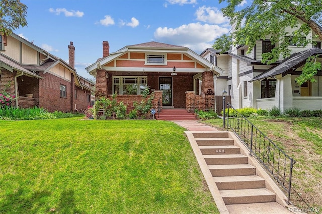 869 S Williams St, Denver, CO 80209 - tudor house featuring brick siding, a front lawn, covered porch, and a chimney