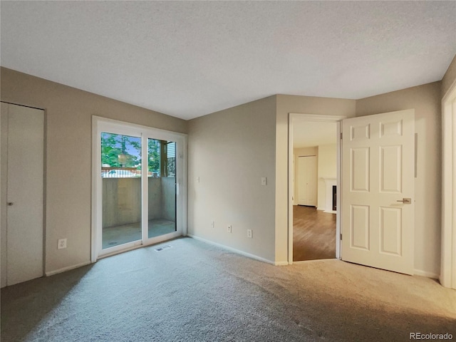 carpeted empty room featuring a textured ceiling