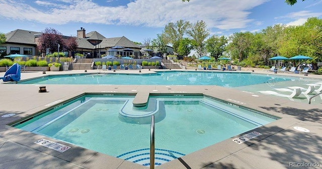 view of swimming pool featuring a hot tub