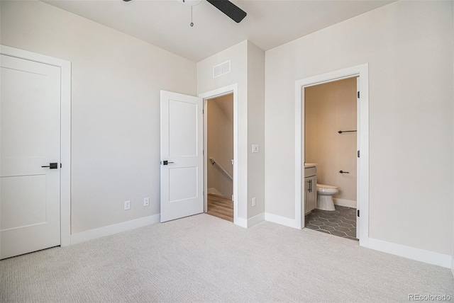 unfurnished bedroom with light carpet, ceiling fan, and ensuite bath