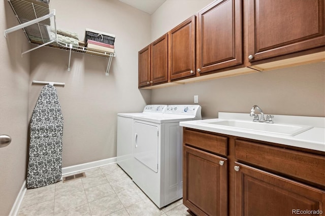 laundry room featuring separate washer and dryer, sink, light tile patterned floors, and cabinets