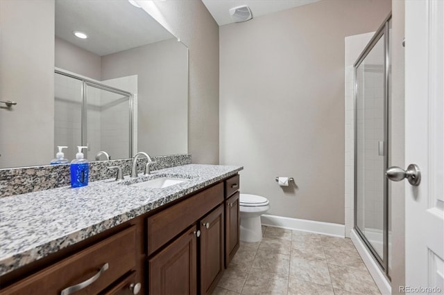 bathroom featuring tile patterned flooring, vanity, a shower with shower door, and toilet