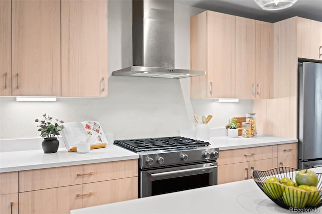 kitchen with wall chimney exhaust hood, appliances with stainless steel finishes, light brown cabinetry, and light countertops