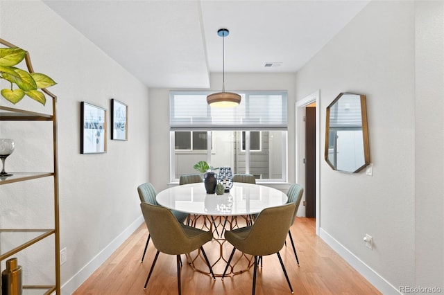 dining space featuring light wood-type flooring and baseboards