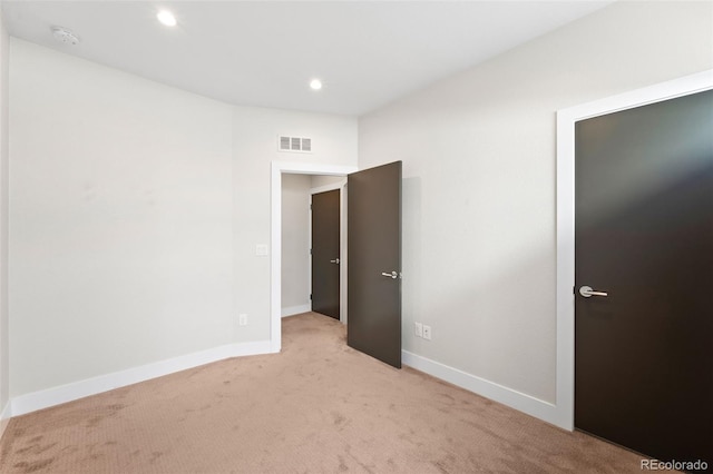 spare room featuring light carpet, baseboards, recessed lighting, and a smoke detector