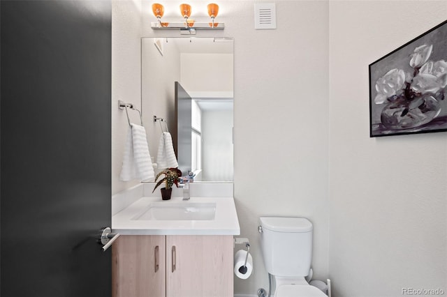 bathroom featuring toilet and vanity