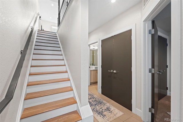 staircase featuring tile patterned flooring and recessed lighting