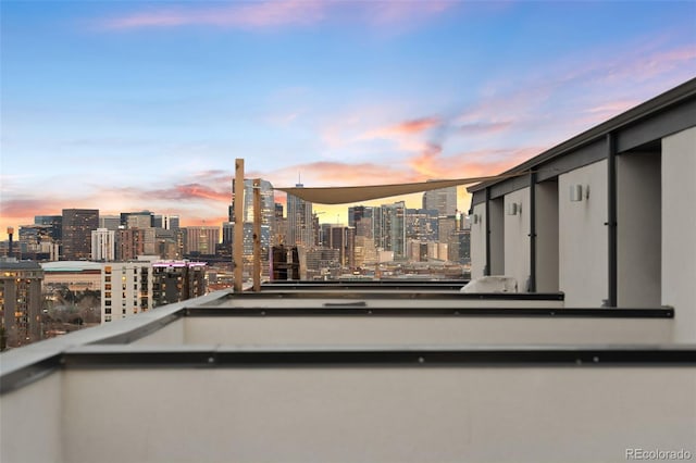 balcony at dusk featuring a city view