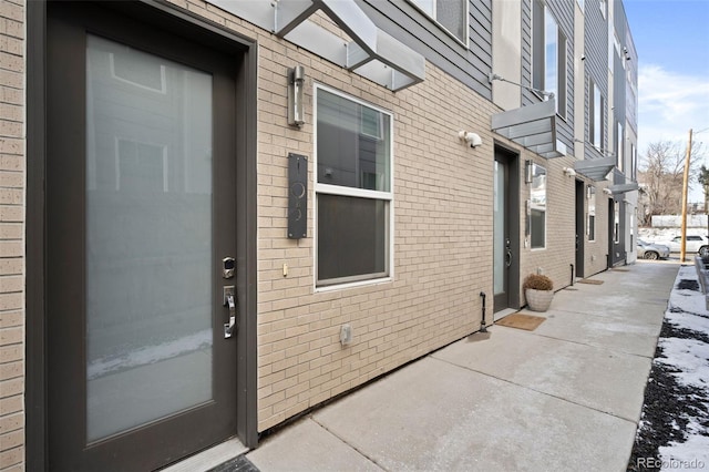 doorway to property featuring brick siding