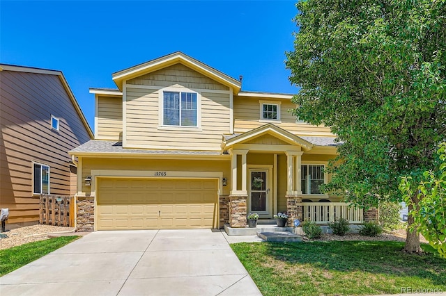 12763 E 105th Pl, Commerce City, CO 80022 - craftsman-style home with a porch, driveway, an attached garage, stone siding, and a front lawn