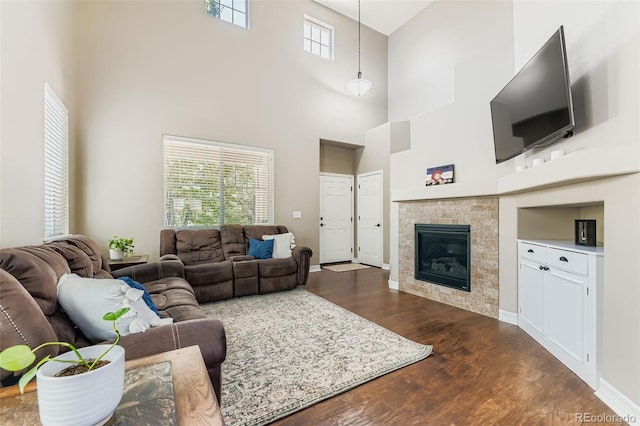 12763 E 105th Pl, Commerce City, CO 80022 - living area featuring dark wood-style floors, a towering ceiling, and a tiled fireplace