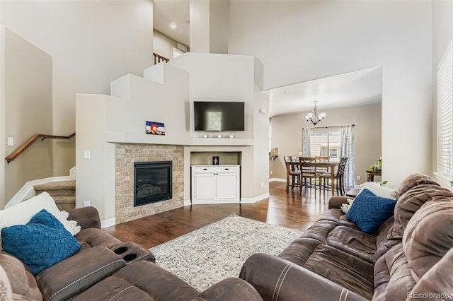 12763 E 105th Pl, Commerce City, CO 80022 - living room with a high ceiling, stairway, wood finished floors, a chandelier, and a glass covered fireplace