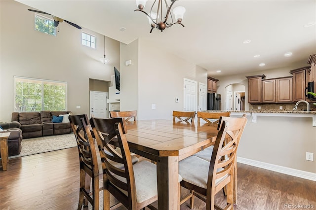 12763 E 105th Pl, Commerce City, CO 80022 - dining space with dark wood finished floors, a chandelier, and arched walkways