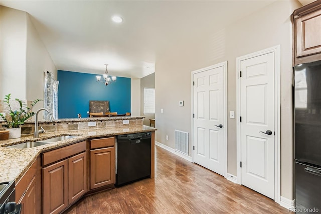 12763 E 105th Pl, Commerce City, CO 80022 - kitchen featuring black dishwasher, freestanding refrigerator, a chandelier, wood finished floors, and recessed lighting