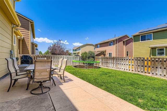 12763 E 105th Pl, Commerce City, CO 80022 - fenced backyard featuring a patio area, outdoor dining space, a trampoline, and a residential view