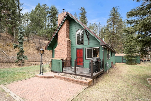 12569 S Parker Ave, Pine, CO 80470 - view of front of property featuring a chimney, a patio area, and a front yard